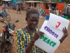 A young South Sudanese woman holds a sign stating 